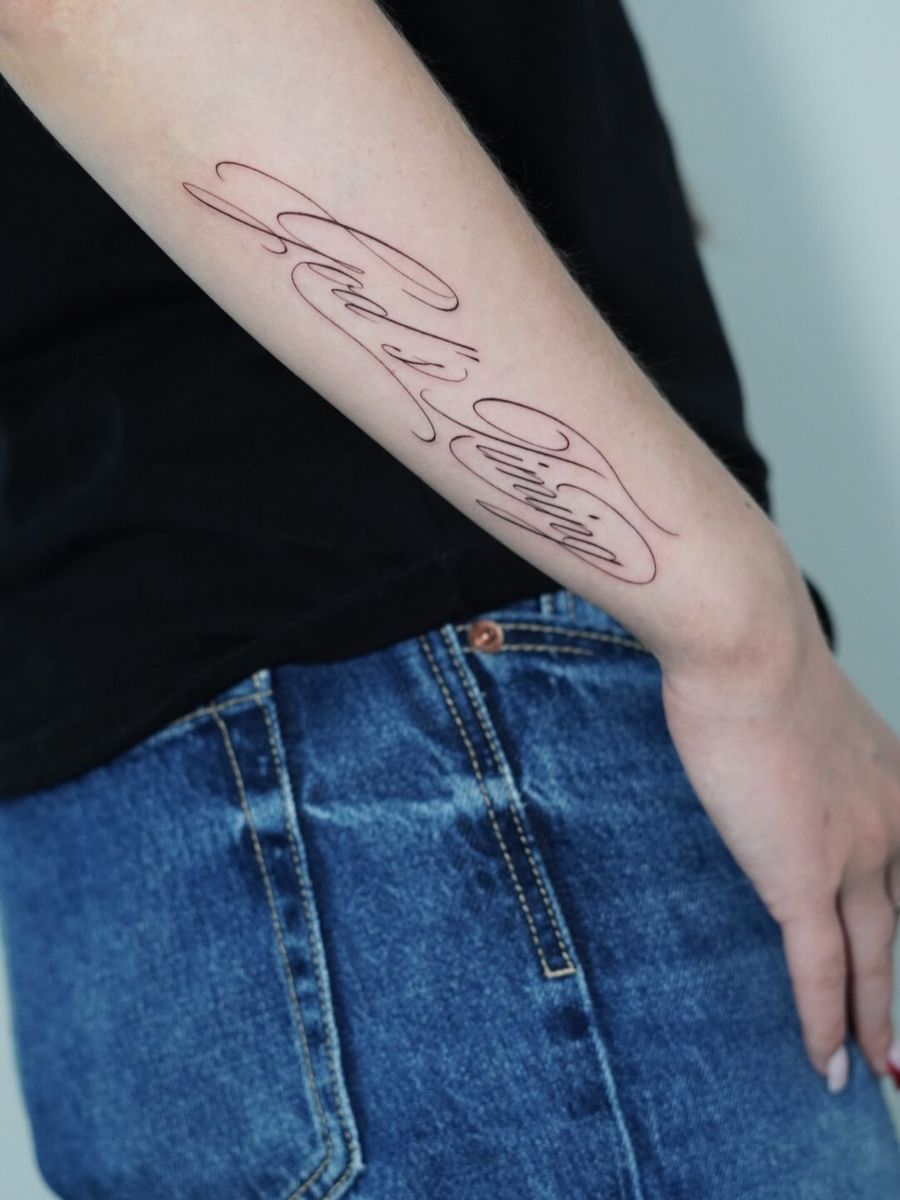 Feiner Schriftzug „God’s Timing“ am Unterarm, gestochen von Max