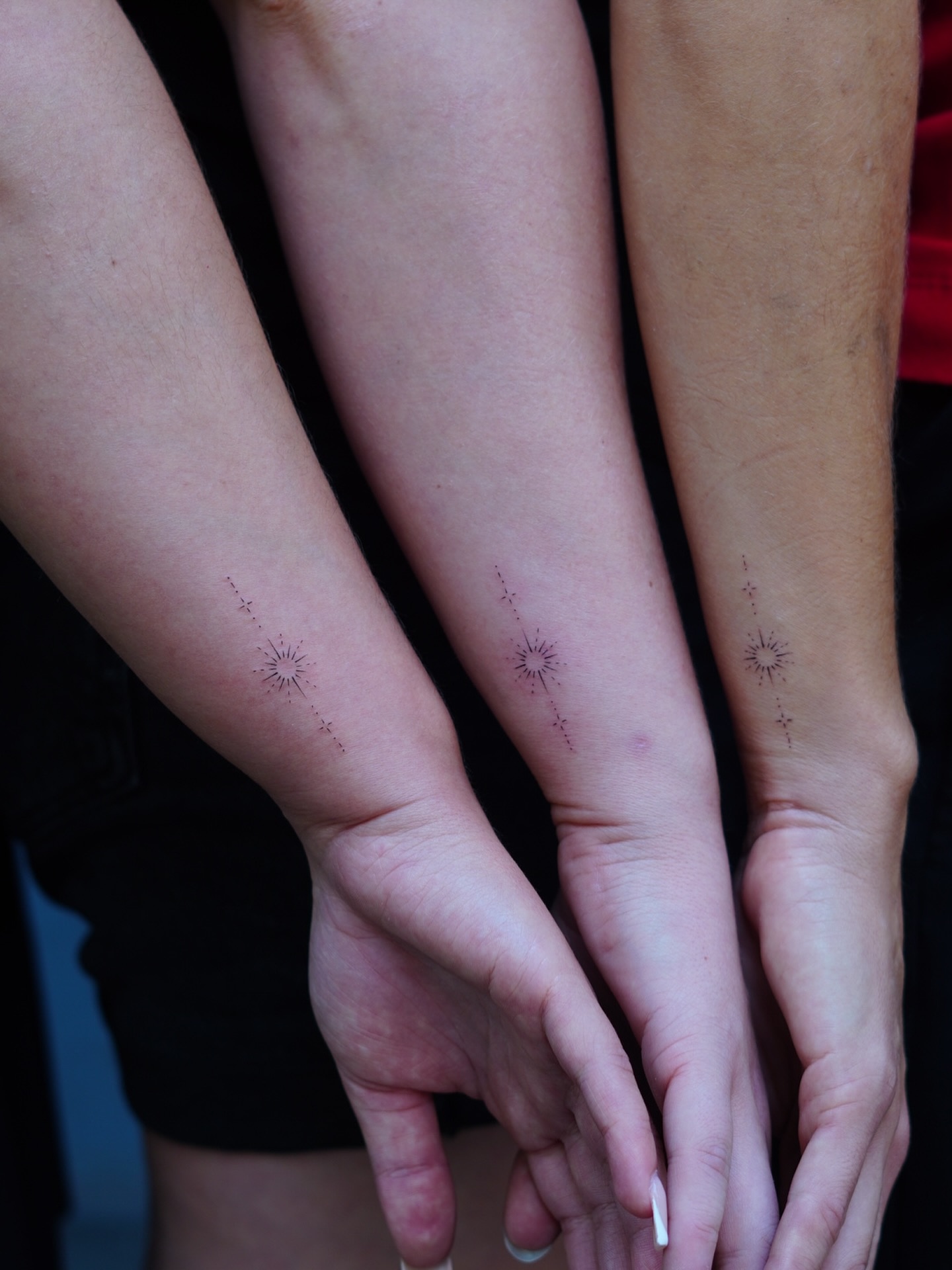 Drei feine Partner-Tattoos mit Sternen an den Unterarmen, gestochen von Max