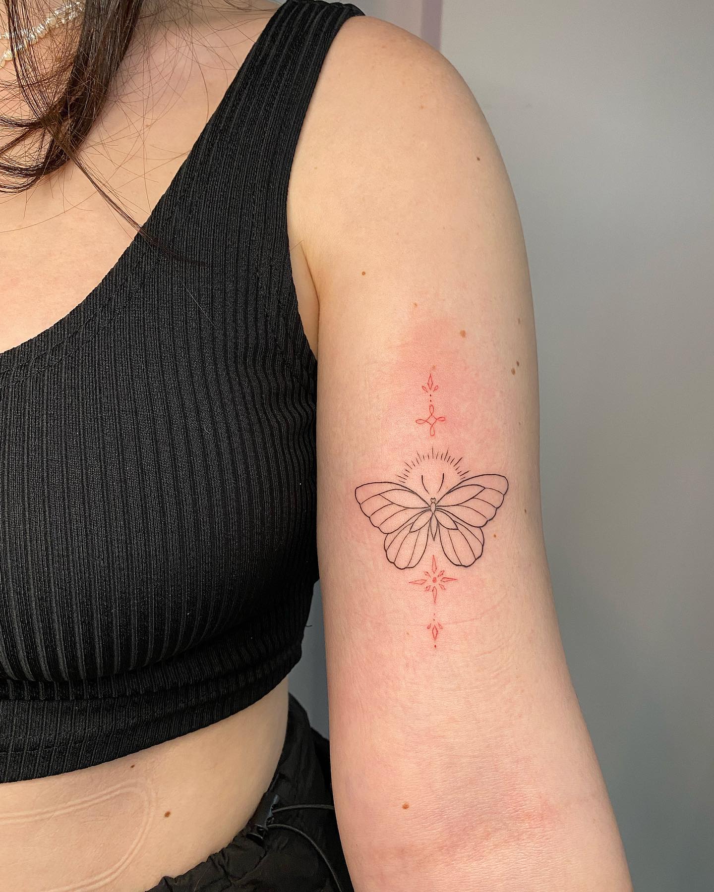 Schmetterling mit Ornament am Oberarm, frisch gestochen von Max